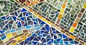 A stunning mosaic of floor tiles laid out in a rough pattern of blues and greens and yellows.